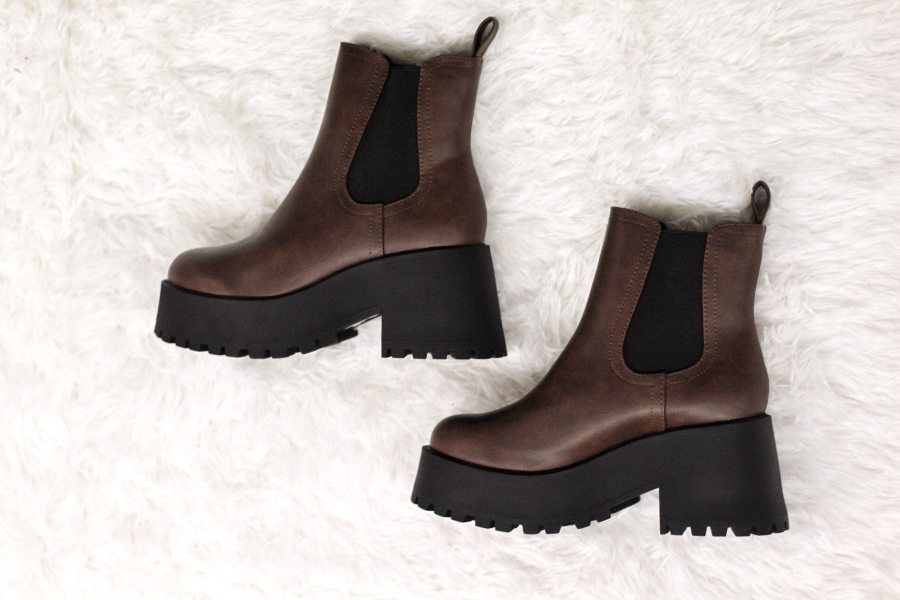 Brown platform chelsea boots on white faux fur